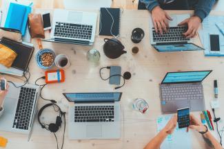 people sitting down near table with assorted laptop computers by Marvin Meyer courtesy of Unsplash.