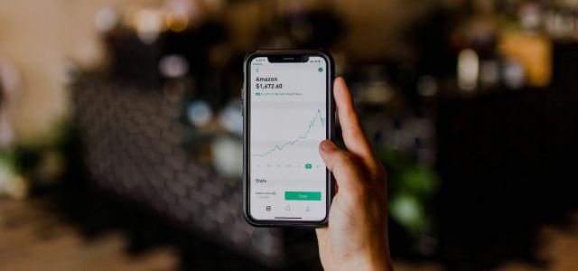 person holding black iPhone displaying stock exchange by Austin Distel courtesy of Unsplash.